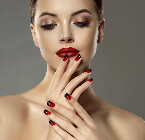 Beautiful model girl with red and black french manicure on nails . Fashion luxury makeup . Beauty and cosmetics . ricostruzione unghie